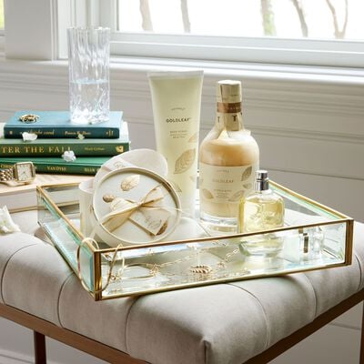 Thymes Goldleaf Eau de Parfum on glass tray with Thymes Goldleaf product assortment